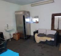 Hospodárska usadlosť  - Interiér rodinného domu s umývadlom, chladničkou, pohovkou a chladičom.