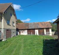 Hospodárska usadlosť  - Rodinný dom v Horných Hámroch so záhradou a drevenou prístavbou, pod modrou oblohou.