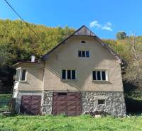 Hospodárska usadlosť  - Rodinný dom v Horných Hámroch v prírode s garážovými dverami a kamennou fasádou.