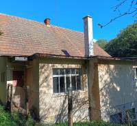 Hospodárska usadlosť  - Rodinný dom v Horných Hámroch s drevenou strechou a za plotom, obklopený zeleňou.