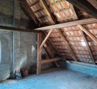 Hospodárska usadlosť  - Podkrovie rodinného domu so strešnými trámami a oknom.
