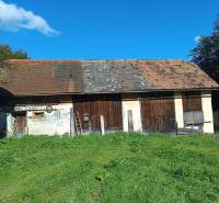 Hospodárska usadlosť  - Budova vedľa rodinného domu v Horných Hámroch s drevenými dverami a trávnatým okolím.