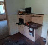 Hospodárska usadlosť  - Staršia kuchyňa v rodinnom dome, s pecou a podlahou s dreveným dekorom.