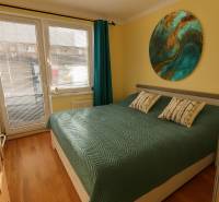 3 izbový byt Zlaté Moravce - Spálňa s podlahou s dreveným dekorom a veľkou posteľou v 3-izbovom byte.