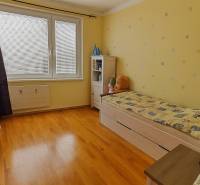 3 izbový byt Zlaté Moravce - Detská izba s posteľou, poličkou a podlahou s dreveným dekorom v 3-izbovom byte.