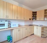 REZERVOVANÉ: NA PREDAJ - 1-izbový byt vo Veľkom Šariši - PREŠOV - Kuchyňa s kuchynskými skrinkami v 1-izbovom byte, vybavená spotrebičmi a podlahou s dreveným dekorom.