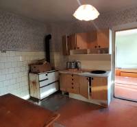 Rodinný dom v obci Dobrá Voda  - Kuchyňa rodinného domu s retro sporákom a svetlou tapetou na stenách.