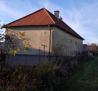 Rodinný dom v obci Dobrá Voda  - Rodinný dom v Dobrej Vode s červenou strechou a oplotením, obklopený zeleňou.