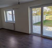 – Podpivničený RD po kompletnej rekonštrukcii - Interiér 3-izbového bytu s veľkými oknami a podlahou s dreveným dekorom.