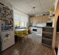 REZERVOVANÉ jednoizbový zrekonštruovaný byt v širšom centre mesta - Kuchyňa s podlahou s dreveným dekorom, jedálenským stolom a chladničkou v 1-izbovom byte.