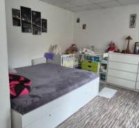 REZERVOVANÉ jednoizbový zrekonštruovaný byt v širšom centre mesta - Izba s podlahou s dreveným dekorom, posteľou a bielou komodou v 1-izbovom byte.