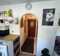 REZERVOVANÉ jednoizbový zrekonštruovaný byt v širšom centre mesta - Interiér 1-izbového bytu s podlahou s dreveným dekorom, poličkami a práčkou.