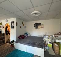 REZERVOVANÉ jednoizbový zrekonštruovaný byt v širšom centre mesta - Izba v 1-izbovom byte s posteľou a detskou postieľkou, podlaha s dreveným dekorom.