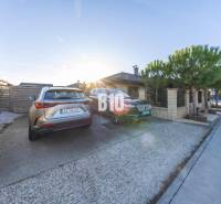 Tri Vody - 4-izbový rodinný dom s bazénom | Most pri Bratislave – Baza - Dvor rodinného domu v Mosti pri Bratislave s parkovacími miestami a zaparkovanými autami.