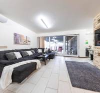 Tri Vody - 4-izbový rodinný dom s bazénom | Most pri Bratislave – Baza - Obývacia izba rodinného domu s pohovkou, krbom a posuvnými dverami na terasu.