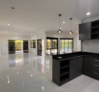 ÚTULNÁ 3 SPÁLŇOVÁ VILA S BAZÉNOM - EAST PATTAYA - Kuchyňa vo vile s bielymi stenami, dlažbou a tmavým nábytkom.