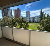 Veľký 2-izb. byt na ul. Vranovská, Petržalka, lodžia, 4.p./7 - Balkón garsónky na Vranovskej ulici v Bratislave - Petržalke s výhľadom na zeleň a paneláky.