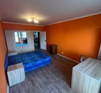 Veľký 2-izb. byt na ul. Vranovská, Petržalka, lodžia, 4.p./7 - Oranžová garsónka s posteľou, skriňou a podlahou s dreveným dekorom.