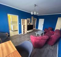 Veľký 2-izb. byt na ul. Vranovská, Petržalka, lodžia, 4.p./7 - Izba s modrými stenami, červeným nábytkom a podlahou s dreveným dekorom.