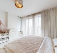 4-izbový MEZONET 105m2 + terasy 28m2 | Petržalka City - Spálňa v 4-izbovom byte s detskou postieľkou, posteľou a závesmi na oknách.