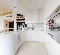 4-izbový MEZONET 105m2 + terasy 28m2 | Petržalka City - Kuchyňa v 4-izbovom byte s bielymi skrinkami a podlahou s dreveným dekorom.