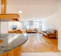 POD HRADOM - ZÁMOCKÁ - 3 IZBOVÝ BYT NA BÝVANIE AJ INVESTÍCIU - Obývacia izba v 3-izbovom byte s podlahou s dreveným dekorom a koženým nábytkom.