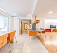 POD HRADOM - ZÁMOCKÁ - 3 IZBOVÝ BYT NA BÝVANIE AJ INVESTÍCIU - Jasná kuchyňa 3-izbového bytu s podlahou s dreveným dekorom a jedálenským stolom.