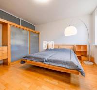 POD HRADOM - ZÁMOCKÁ - 3 IZBOVÝ BYT NA BÝVANIE AJ INVESTÍCIU - Spálňa s posteľou, vstavanou skriňou a podlahou s dreveným dekorom v 3-izbovom byte.