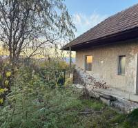 RD TVRDOMESTICE, pozemkom s prístupom z oboch strán - Rodinný dom v Tvrdomesticiach pri západe slnka, v obklopení zelenej vegetácie.