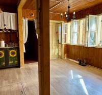 Záhrada s chatou s čarovným výhľadom, BA – Karlova Ves - V interiéri s podlahou s dreveným dekorom dominuje rustikálny nábytok a jasné osvetlenie.