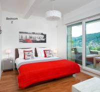 KRÁSNA MODERNÁ VILA  /400 m²/ s výhľadom na more, ostrov BRAČ - Spálňa vo vile s podlahou s dreveným dekorom, posteľou a balkónom s výhľadom.