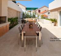 KRÁSNA MODERNÁ VILA  /400 m²/ s výhľadom na more, ostrov BRAČ - Vila v meste Bol s vonkajšou terasou, stolom a grilom obklopená rastlinami.