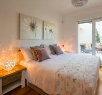 KRÁSNA MODERNÁ VILA  /400 m²/ s výhľadom na more, ostrov BRAČ - Spálňa vo vile s podlahou s dreveným dekorom, jemnými obrazmi a veľkými oknami.