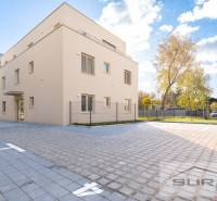 2-izbový byt s predzáhradkou 135 m² a parkovaním v tichej časti BA - Budova na Železničnej ulici v Bratislave - Vrakuni, obklopená dlaždeným priestorom a zeleňou.