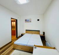 Na predaj rekreačná chata s pozemkom, Domaša, Valkov - Izba v Chate s dvoma posteľami, bielymi stenami a podlahou s dreveným dekorom.