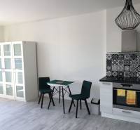 PRENÁJOM 1i byt s Loggiou, Tomášikova ul., Ružinov - Kuchyňa v 1-izbovom byte s podlahou s dreveným dekorom a stolom na jedlo.