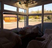 EXKLUZÍVNE, VEĽKÝ RODINNÝ DOM NECPALY - Zimná záhrada rodinného domu s ratanovým nábytkom a výhľadom do dvora.