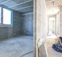 Rodinný dom Hontianske Tesáre - Interiér rozostavaného Rodinného domu s betónovými stenami a veľkými oknami.
