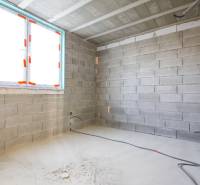 Rodinný dom Hontianske Tesáre - Interiér s nedokončenými stenami, inštaláciou elektrických káblov a oknom v rodinnom dome.