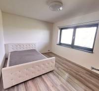 Rodinný dom v obci Dubová s 920m2 rozsiahlym pozemkom  - Spálňa v rodinnom dome s posteľou a podlahou s dreveným dekorom.