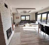 Rodinný dom v obci Dubová s 920m2 rozsiahlym pozemkom  - Interiér rodinného domu s pohovkou, krbom a podlahou s dreveným dekorom.