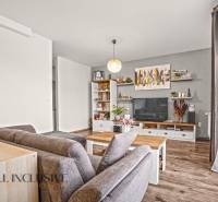 NA PREDAJ 2-IZBOVÝ BYT S 2 BALKÓNMI, DUNAJSKÁ STREDA - Obývacia izba v 2-izbovom byte s podlahou s dreveným dekorom, pohodlným sedením a dekoráciami.