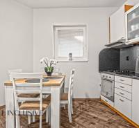 NA PREDAJ 2-IZBOVÝ BYT S 2 BALKÓNMI, DUNAJSKÁ STREDA - Kuchyňa v 2-izbovom byte s jedálenským stolom a podlahou s dreveným dekorom.