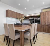 PREDAJ-2 IZBOVÝ BYT-KOMPLETNÁ REKONŠTRUKCIA - RUŽINOV - Kuchyňa v 2-izbovom byte s nábytkom z dreveným dekorom a svetlými stenami.