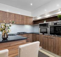 PREDAJ-2 IZBOVÝ BYT-KOMPLETNÁ REKONŠTRUKCIA - RUŽINOV - Kuchyňa v 2-izbovom byte, drevený dekor, biele obklady, vstavané spotrebiče.