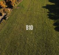 VOĽNÉ  2 zo 4 - Slnečné pozemky Petrovice-Setechov - Trávnatý pozemok na bývanie v Petroviciach, obklopený zeleňou a stromami.