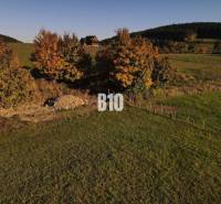 VOĽNÉ  2 zo 4 - Slnečné pozemky Petrovice-Setechov - Pozemok v Petroviciach na bývanie, obklopený stromami v jesenných farbách.