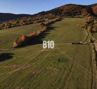 VOĽNÉ  2 zo 4 - Slnečné pozemky Petrovice-Setechov - Krajina s pozemkami na bývanie v Petroviciach, obklopená kopcami a lesmi na jeseň.