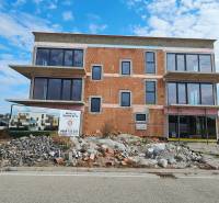 3i. BYT S VLASTNÝM TEP. ČERPADLOM + KLIMATIZÁCIA A EXTERIÉROVÉ ŽALÚZIE - Budova vo výstavbe s veľkými oknami na Dúhovej ulici v Slovenskom Grobe.