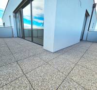 3i. BYT S VLASTNÝM TEP. ČERPADLOM + KLIMATIZÁCIA A EXTERIÉROVÉ ŽALÚZIE - Terasové dlaždice na balkóne 3-izbového bytu s presklenými dverami.